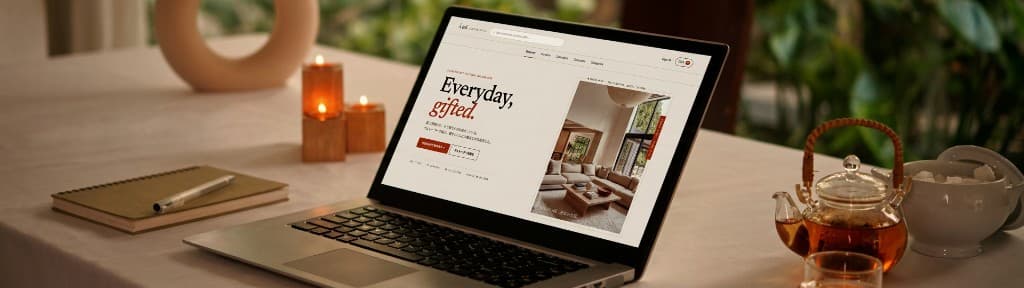 ノートPCに映る À toi のトップページと、卓上のキャンドルやお茶
