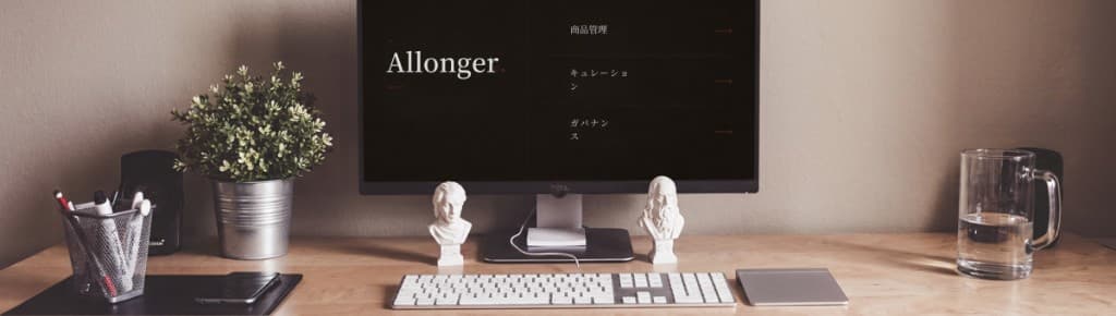 デスク上のモニターに映る Allonger の画面とキーボード